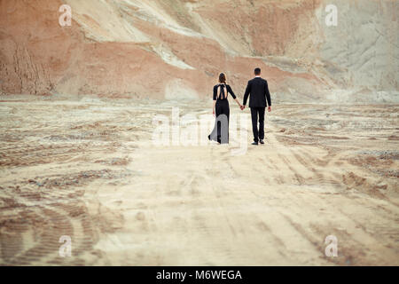 The bride and groom dressed in black are leaving Stock Photo