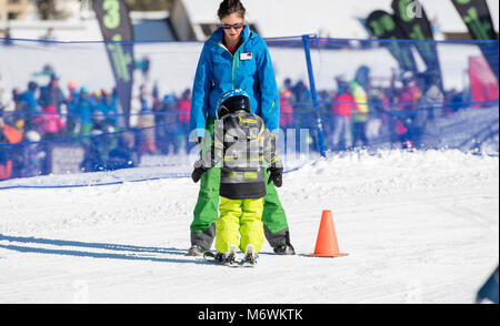 Ski Instructor with 3-Year Old Toddler Boy at a Mountain Resort Stock Photo