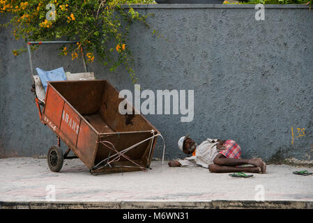Horizontal portrait of a homeless man sleeping on the streets of Colombo, Sri Lanka.