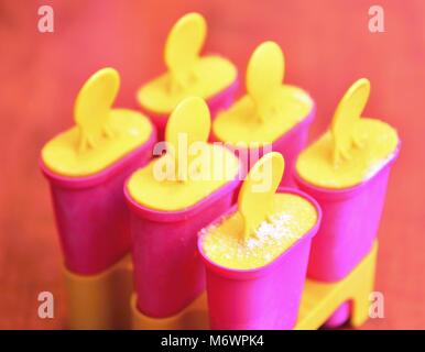 Homemade popsicles in pink ice cream plastic makers or molds. Stock Photo