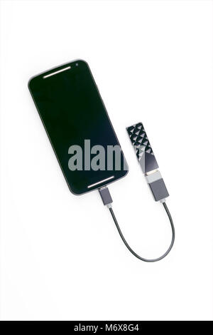 Black smartphone connected to a USB key with an OTG cable. Isolated on white background Stock Photo