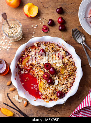 Peach and berry crumble in a baking dish. Top view Stock Photo
