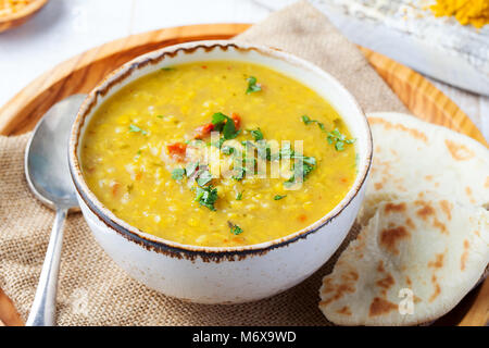 Lentil soup with pita bread in a ceramic white bowl on a wooden background. Close up. Stock Photo