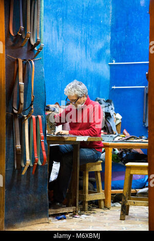 A leather artisan working in his workshop in Fes, Morocco Stock Photo