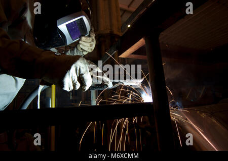 man doing welding jobs inside an industry Stock Photo