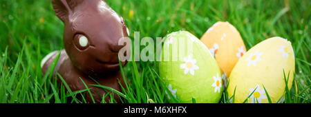 Chocolate bunny in the grass with easter eggs Stock Photo
