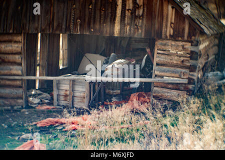 A 1948 Ford 8N tractor in an old log barn, by the road along Smart Creek, in the John Long Mountains. Stock Photo