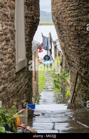 very narrow passageway between houses in Stromness, Orkney, Scotland, UK leading to gardens and the water front Stock Photo