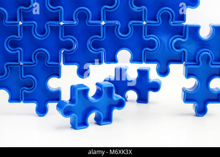 Pieces from a blue jigsaw puzzle arranged to form a page on white background. Break barriers together for autism. Stock Photo