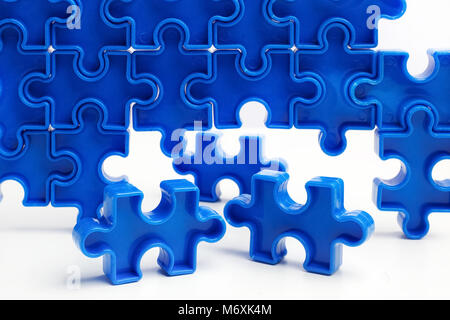 Pieces from a blue jigsaw puzzle arranged to form a page on white background. Break barriers together for autism. Stock Photo
