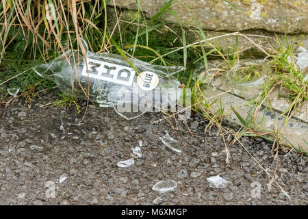 Broken smashed WKD alcohol glass bottle on footpath in Scotland, UK Stock Photo
