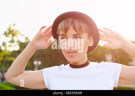 Young beautiful woman saying something while walking in park Stock Photo