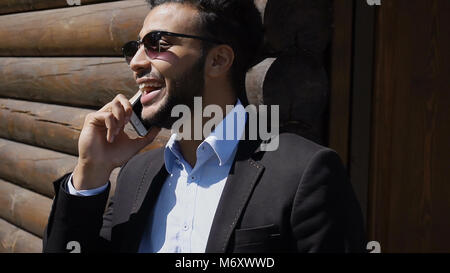 Economist talking with boss on phone, smiling with dimples on fa Stock Photo