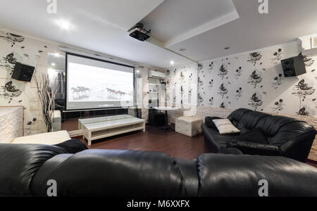 MOSCOW - JULY 2014: Interior of the hookah and anticafe 'MELLOW-YELLOW'. Room with black leather sofas and a cinema Stock Photo