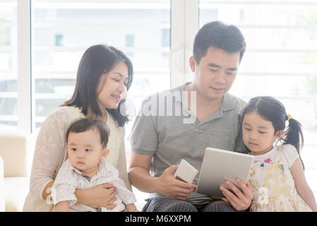 Father using tablet pc and smart phone. Asian family at home, natural living lifestyle indoors. Stock Photo