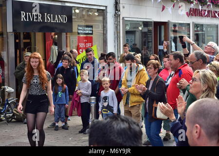 Female dancer performing dance on Irish folk music in streets of Galway while crowd is watching. Stock Photo