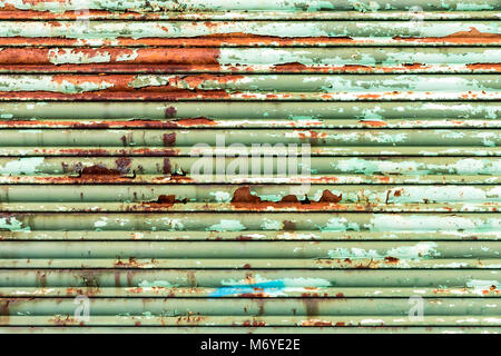 Metalic roller shutter painted green with rust, to use as background Stock Photo
