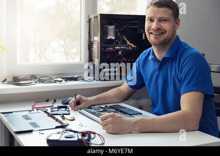 smiling young electronics technician at work Stock Photo