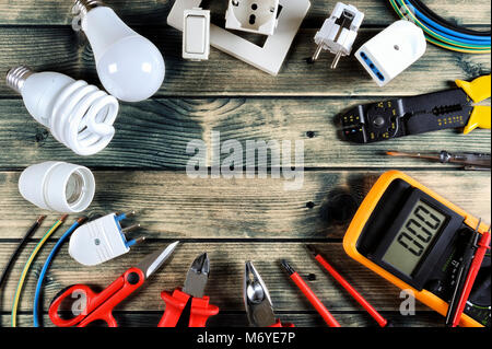 Close-up of work tools and electrical equipment on an antique wooden table with space for text / announcement Stock Photo