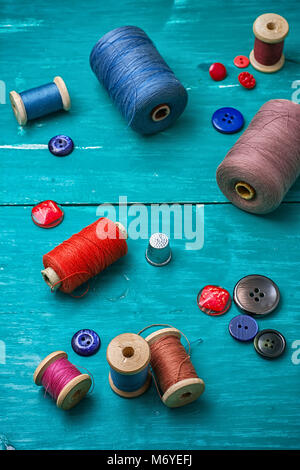 thread buttons for crafts on turquoise wooden background.Selective ...