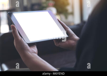 Mockup image of hands holding black tablet with blank white desktop screen Stock Photo