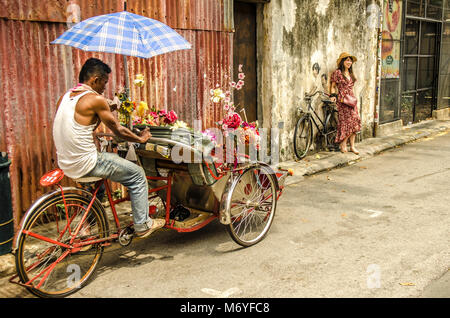 Girl posing for photo by famous street art in George Town, Malaysia Stock Photo