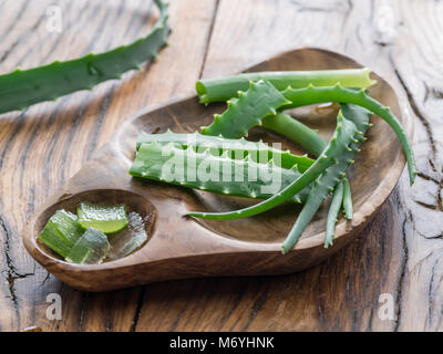 Aloe or Aloe vera fresh leaves and slices on wooden table. Stock Photo