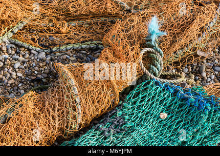 Close up of discarded fishing nets on a gravel beach Stock Photo