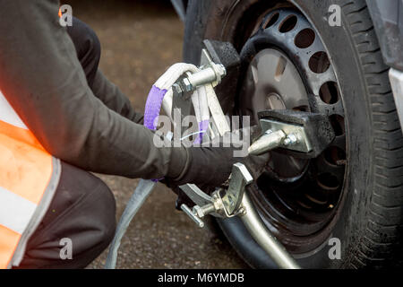 Wheel clamping of untaxed vehicles is becoming more common with the paper tax disc display being abolished and car tax needing to be paid online. Stock Photo