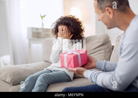 Loving daddy holding a gift for his daughter Stock Photo