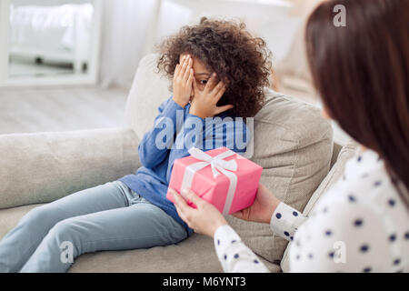 Loving mother holding a gift for her daughter Stock Photo
