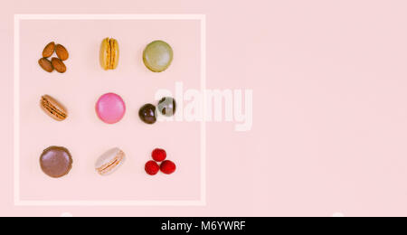 Colorful macaroons on the pastel pink background. Stock Photo