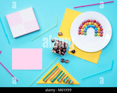 Colorful still life with sweets and present on blue background. Stock Photo