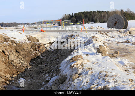 SALO, FINLAND - FEBRUARY 3, 2018: Trench for laying underground power cable at a rural work site on a cold day of winter. Stock Photo