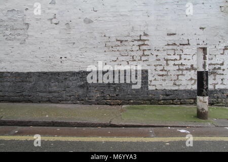 Black and white post against brickwall Stock Photo