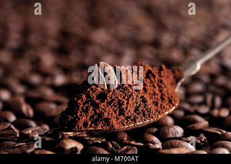 Coffee beans pile on the background of ground coffee Stock Photo
