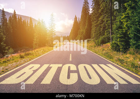 Bitcoin word written on road in the mountains Stock Photo