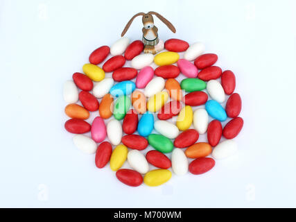 Funny Easter bunny with many colorful sugar eggs Stock Photo