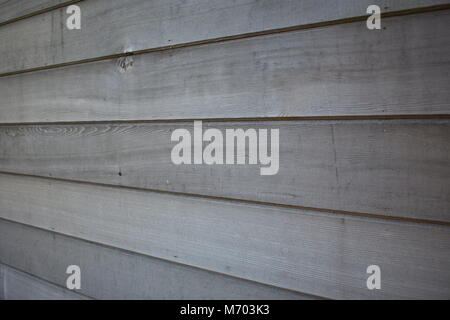 A close-up view of a horizontally panelled red cedar wood wall, showcasing natural grain, texture, and weathered tones turned grey Stock Photo