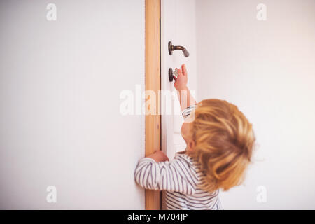 Toddler boy in a dangerous situation at home. Stock Photo