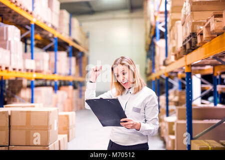 Overjoyed female worker or supervisor in a warehouse. Stock Photo