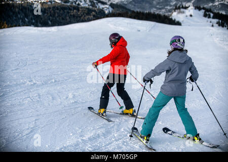 A female ski instructor teaches a woman in the French alpine resort of Courchevel. Stock Photo