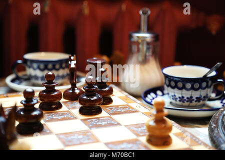 Chessboard on a coffee table on the background of morning light. Background. Stock Photo