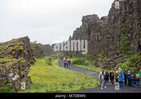 Thingvellir, Iceland - July 19, 2017: Tourists walk through the Almannagja fault line in the mid-atlantic ridge north american plate in Thingvellir Na Stock Photo