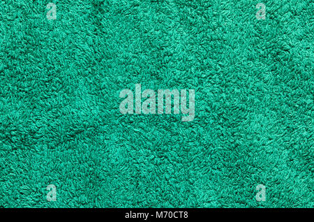 Abstract background of shaggy green carpet pile. Cloth texture with long fibers Stock Photo