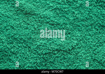 Abstract background of shaggy green carpet pile. Cloth texture with long fibers Stock Photo