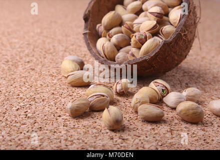 handmade bowl of coconut with pistachios on a wooden table. Close-up. Stock Photo
