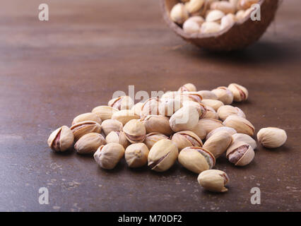 handmade bowl of coconut with pistachios on a stone table. Close-up. Stock Photo
