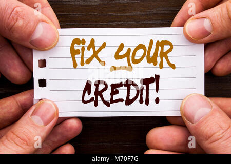 Handwritten text sign showing Fix Your Credit. Business concept for Bad Score Rating Avice Fix Improvement Repair written Sticky Note Paper Holding Ha Stock Photo