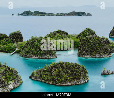 Painemo, Group of small island in shallow blue lagoon water, Raja Ampat, West Papua, Indonesia Stock Photo